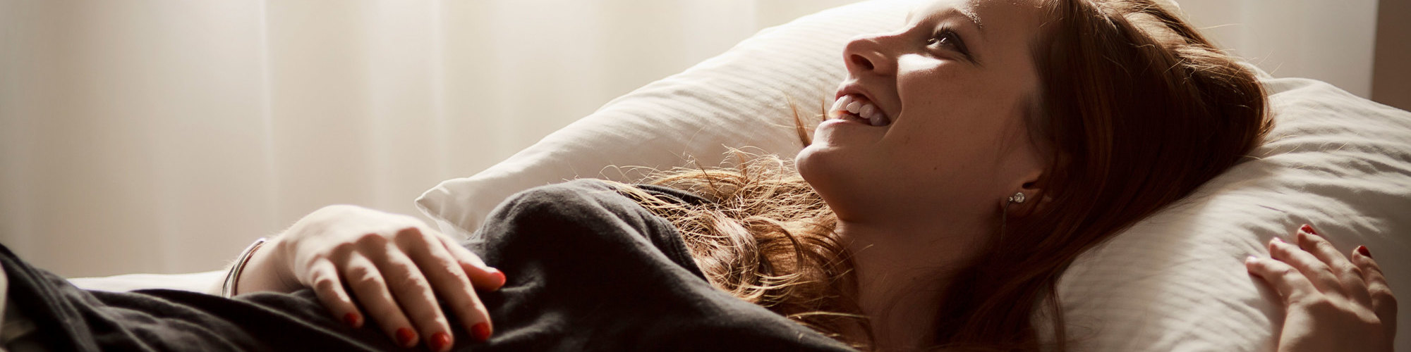 Young woman stretched out on a bed