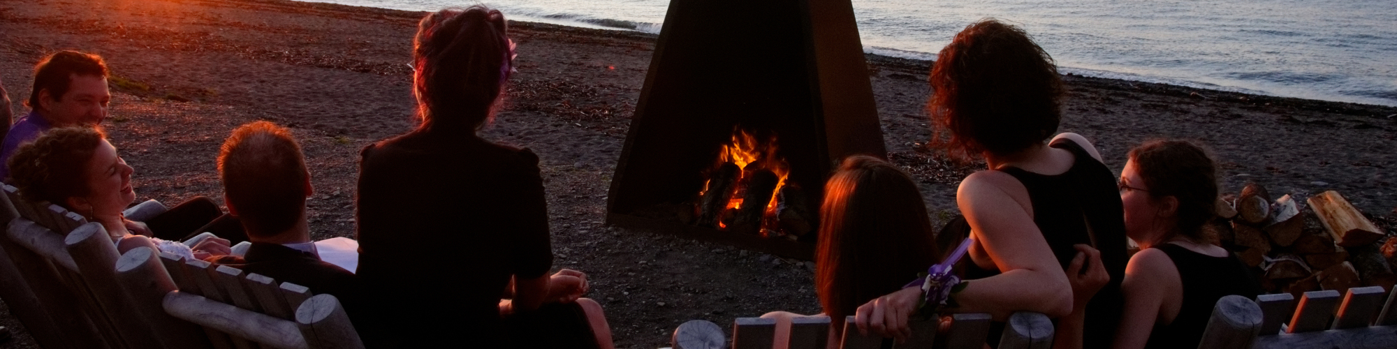 Personnes autour d'un feu de grève, coucher de soleil