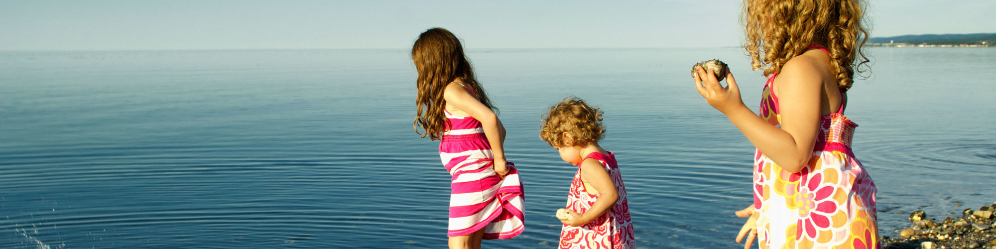 3 little girls playing in the water on the beach