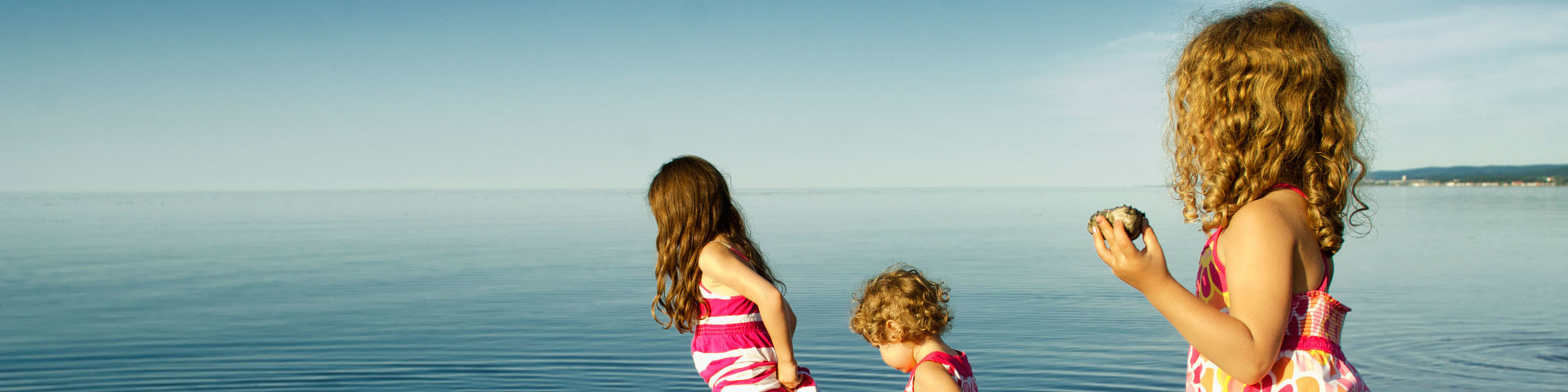 3 little girls playing in the water, on the beach