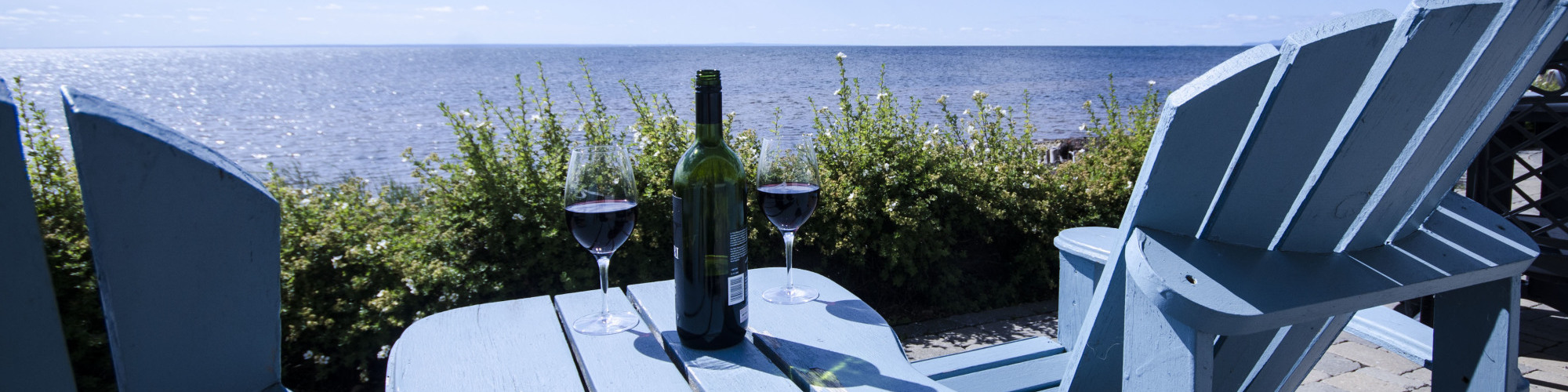 2 chairs on a terrace, sea view, wine glasses