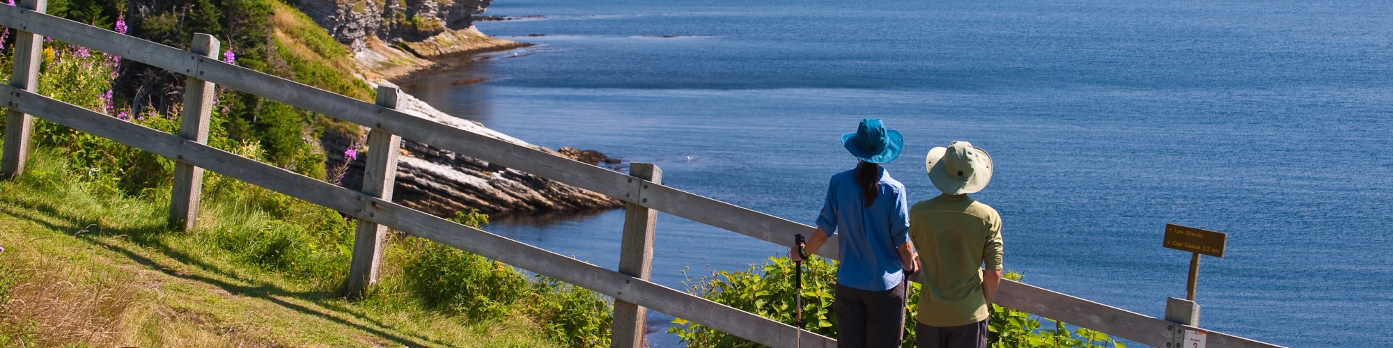 Deux personnes en randonnée, observent le paysage, bord de mer