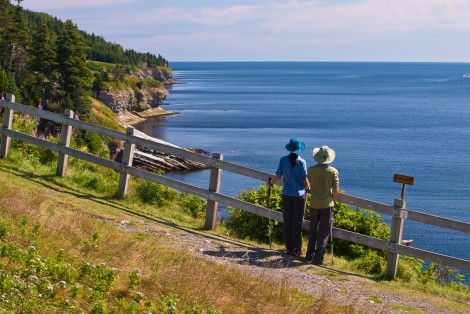 Deux personnes en randonnée, observent le paysage, bord de mer