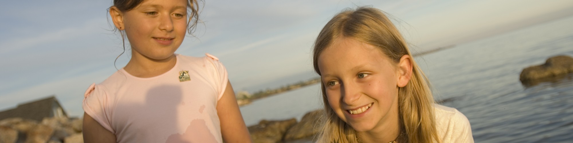 Little girls, by the sea, crab on a rock