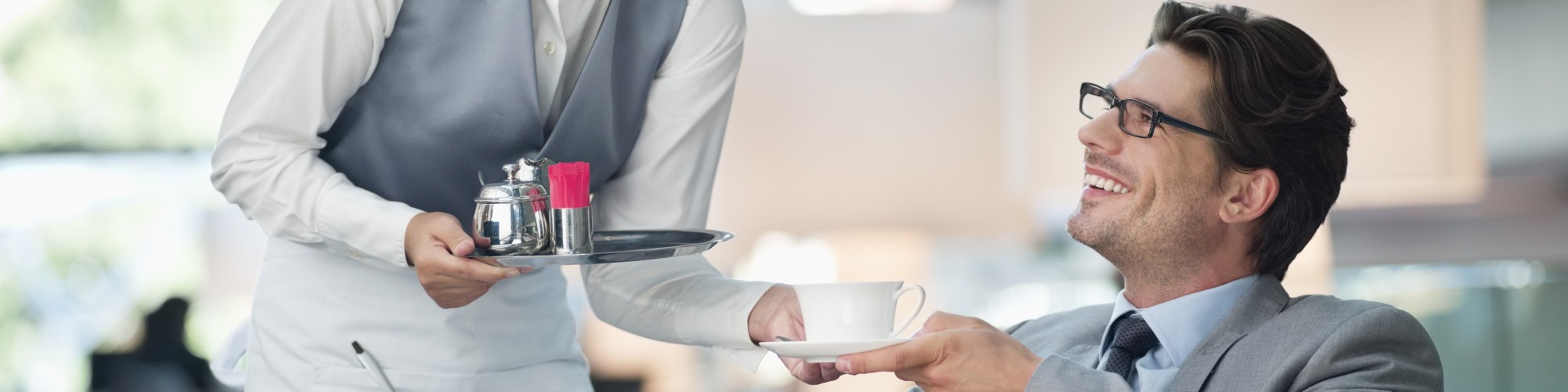 Waitress serving coffee to a business man