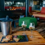 Saut de champagne servi avec un verre et un tartare de saumon, posés sur une table dans un salon d’attente